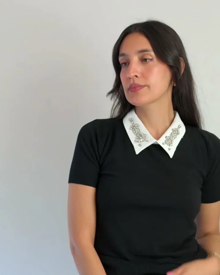 Modelo con sweater negro y cuello blanco